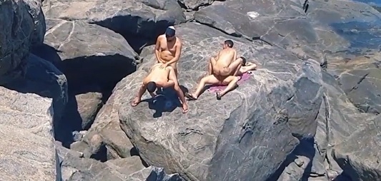 Group of guys fuck on the rocks by the sea